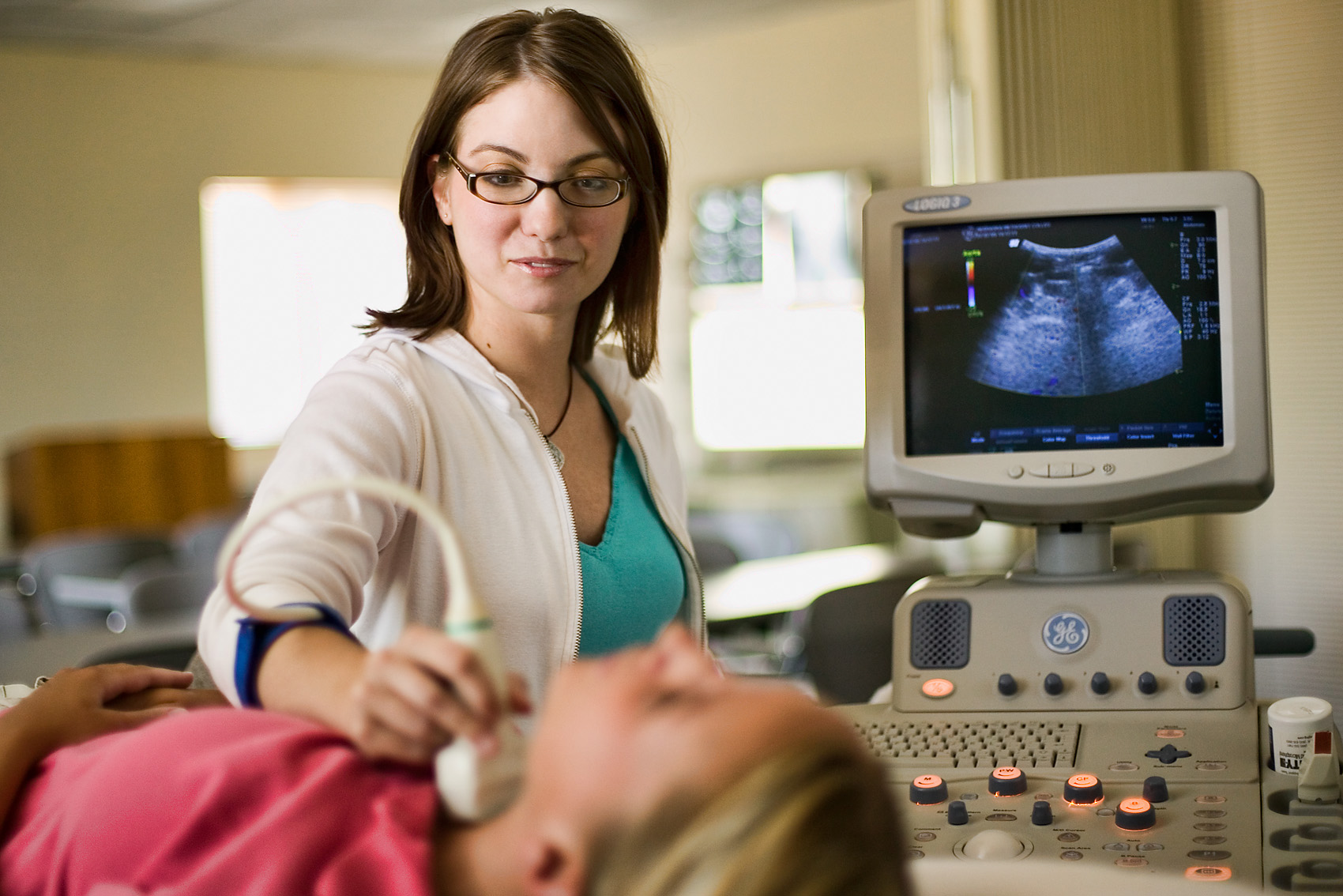Nurse doing ultrasound on thyroid.